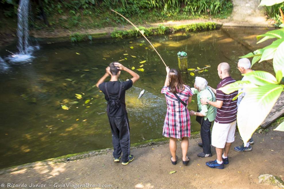 Imagem de pessoas pescando truta no Restaurante Truta Viva em Penedo.